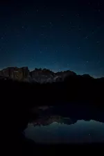 breathtaking-scenery-starry-sky-rocky-cliffs-reflecting-lake-night-time.webp