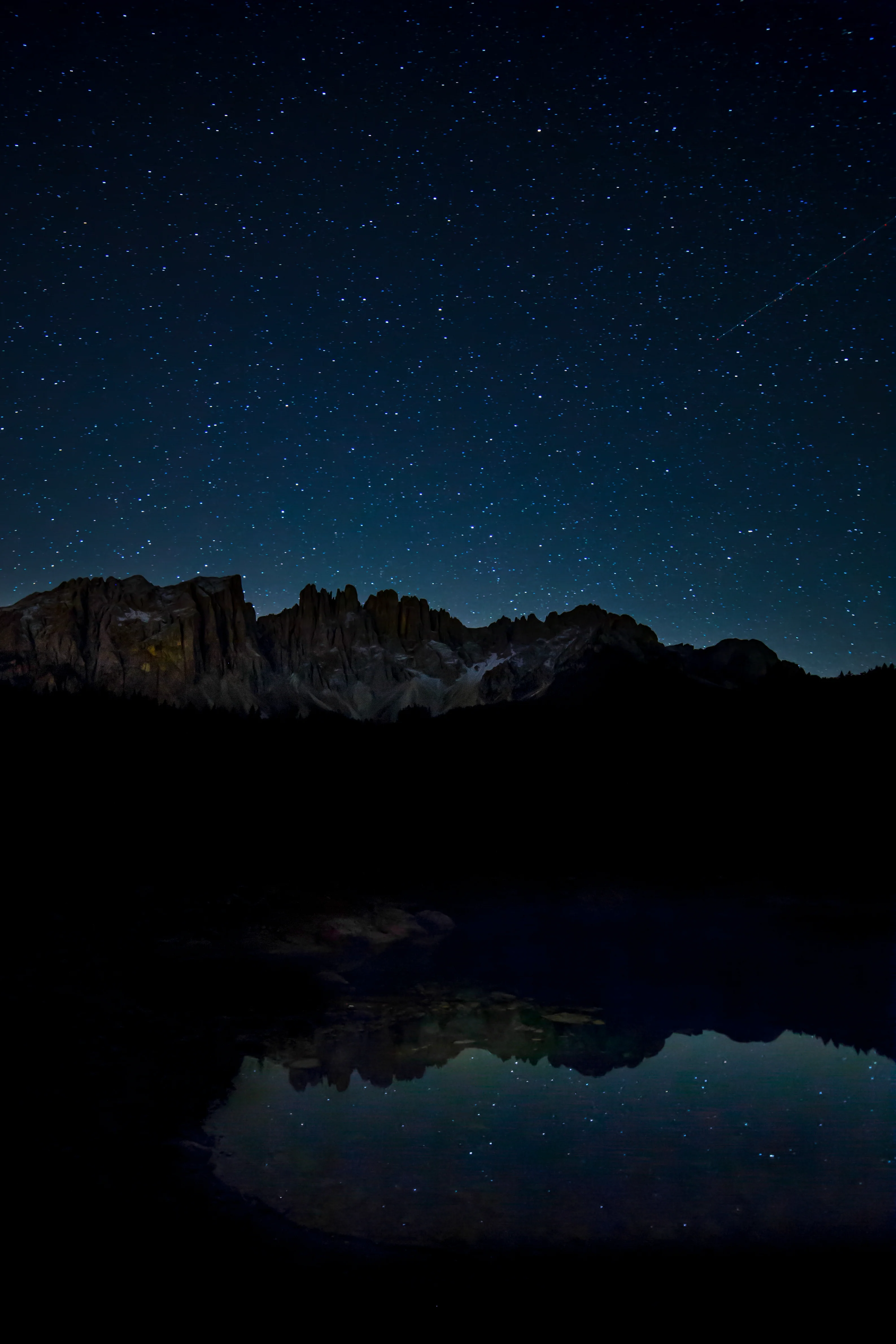 breathtaking-scenery-starry-sky-rocky-cliffs-reflecting-lake-night-time.webp